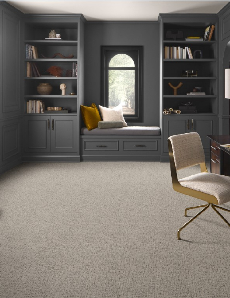 stylish office with durable beige carpet, gray walls, built bookshelves and window seat. 